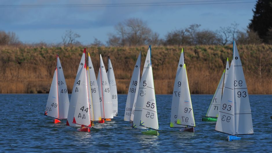 Flotte de voiliers miniatures sur un plan d’eau
